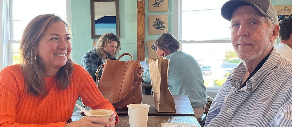 A group of people sitting at a table with bags.