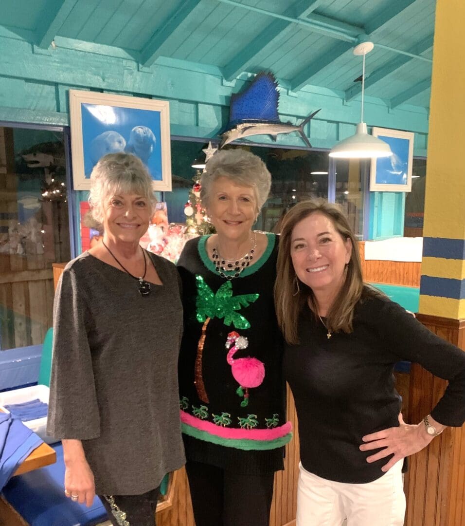 Three women standing next to each other in a room.